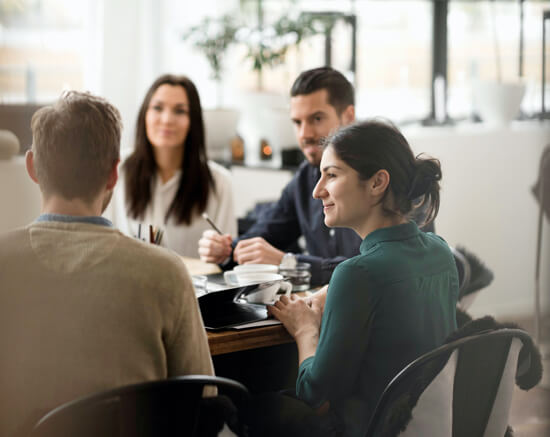 Colleagues work together at a boardroom table